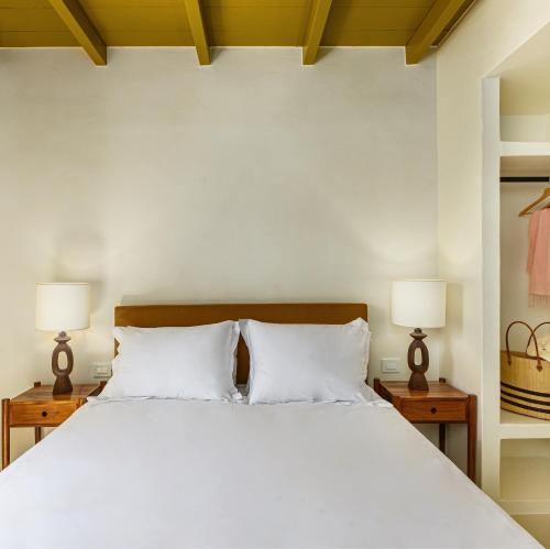 斯派赛斯Teresa Spetses的一间卧室配有一张带两盏灯的大型白色床。