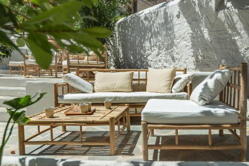 斯派赛斯Teresa Spetses的庭院设有长椅和带枕头的桌子。