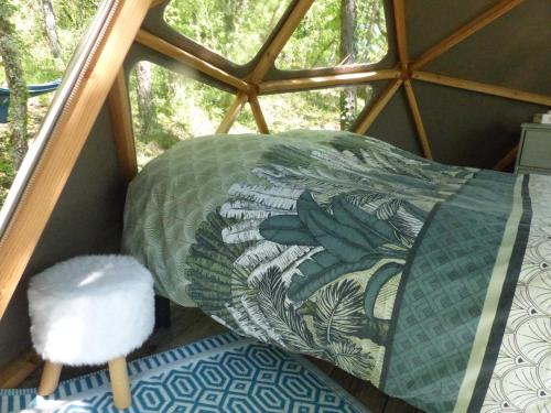 蒙蒂尼亚克"Sweet'dôme" dôme géodésique au cœur de la forêt的客房设有床、枕头和窗户。