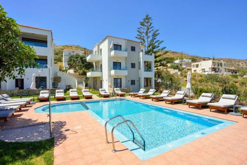 科林瓦里奥Panthea Luxury Living的一座带躺椅的游泳池和一座建筑