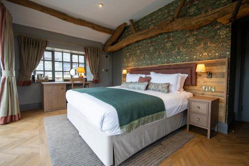 霍克斯黑德女王头旅店及餐馆的一间卧室设有一张大床和绿色的墙壁