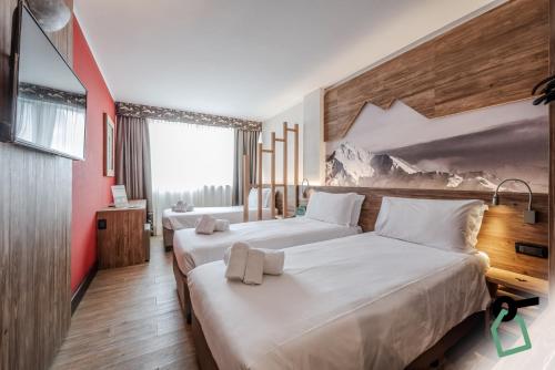 塞斯特雷HOTIDAY Chalet Sestriere Vialattea的红色墙壁的酒店客房内的两张床