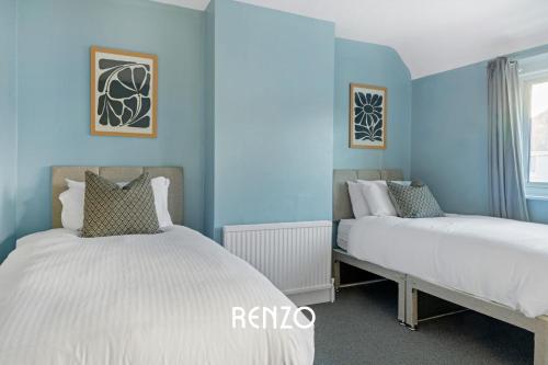 比斯顿Immaculate 3-Bed Home in Nottingham by Renzo, Perfect for Contractors, Free Parking!的卧室设有两张床铺和蓝色的墙壁