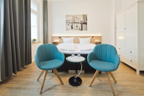 诺德奈Haus Menno Janssen - Doppelzimmer的配有2把椅子和一张桌子的房间