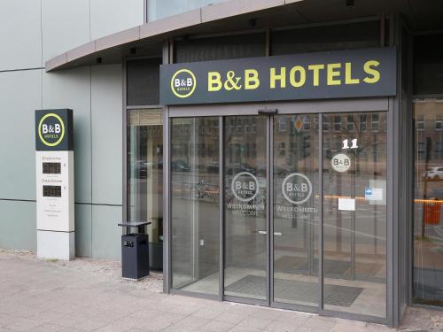 柏林B&B Hotel Berlin City-West的带有bbb酒店标志和旋转门的建筑