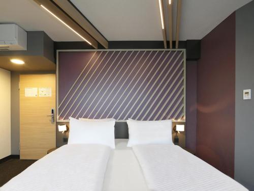 柏林B&B Hotel Berlin City-West的配有床头板的酒店客房内的两张床