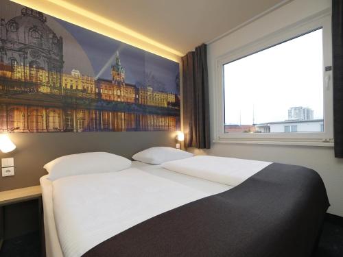 柏林B&B Hotel Berlin City-West的一间卧室设有一张大床和一个大窗户