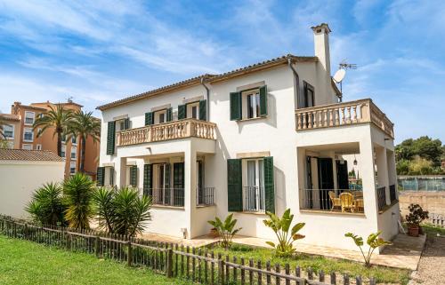 帕尔马海滩Houm Villa Samil的一座带绿色百叶窗的大型白色房屋