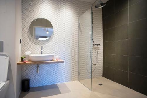 圣西尔·奥芒特Domaine Les Lanternes的带淋浴、盥洗盆和镜子的浴室