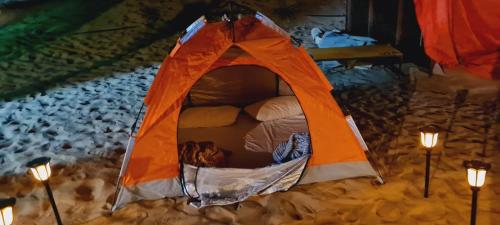 HunaywahRoyal Desert Tourism LLC的雪中带灯的橙色帐篷