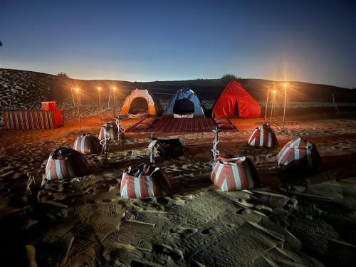 HunaywahRoyal Desert Tourism LLC的一群夜晚在沙漠中的帐篷