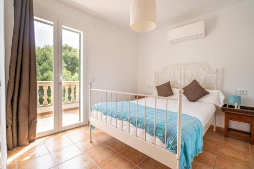 帕尔马海滩Houm Villa Samil的一间白色卧室,配有床和阳台