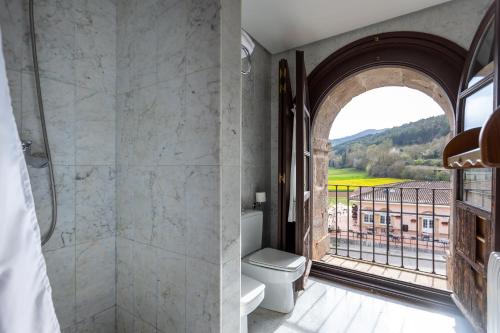 圣米良德拉科戈利亚圣米良莫纳斯特瑞酒店的带淋浴和卫生间的浴室以及窗户。