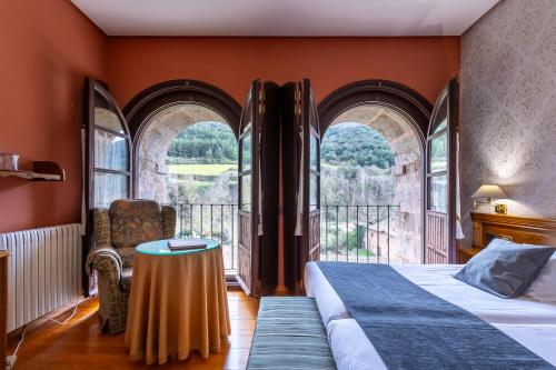 圣米良德拉科戈利亚圣米良莫纳斯特瑞酒店的一间卧室配有一张带桌子和窗户的床。