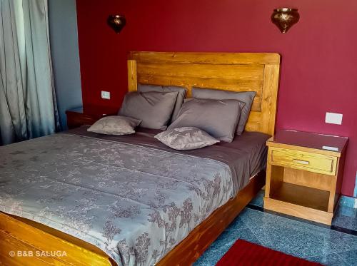 阿斯旺B&B Saluga Sehel Island Nubian House的一间卧室配有一张带木制床头板的床
