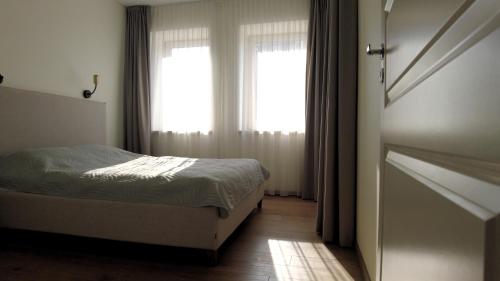 考纳斯Žalio kalno apartamentai的一间卧室设有一张床和一个窗口