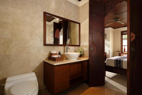 金巴兰Jimbaran Beach Villas by Nakula的一间带水槽和卫生间的浴室以及一张床