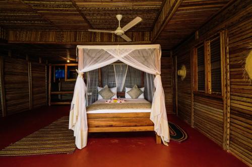 基林多尼Maisara Mafia Beach Lodge的配有吊扇的客房内的一张床位