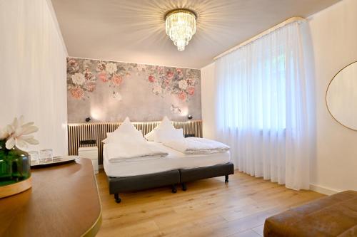 科赫姆泽赫霍夫酒店的一间卧室设有一张床和鲜花墙
