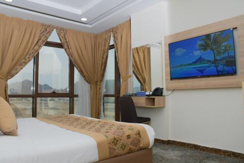 Qabāʼفندق ريست ان的酒店客房,设有床铺和墙上的电视