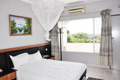利隆圭CROWN HOTEL INTERNATIONAL的卧室配有白色的床和窗户。