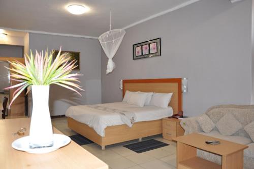 利隆圭CROWN HOTEL INTERNATIONAL的一间卧室,配有一张床和一个花瓶