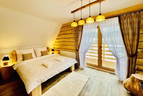 扎科帕内Luxury Houses & Apartments Zaliński的一间卧室设有一张床和一个大窗户