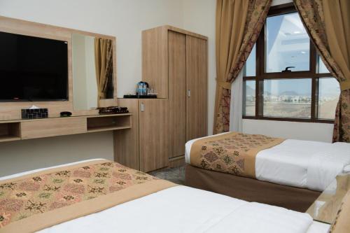 Qabāʼفندق ريست ان的酒店客房设有两张床和电视。