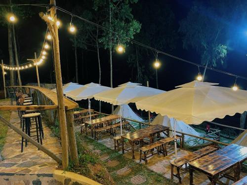 河江Best View Đồng Văn的一组桌子,晚上有雨伞