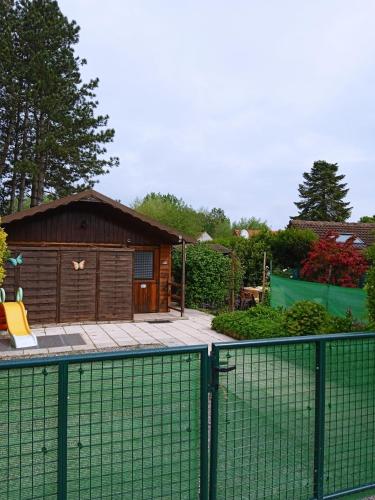 ArdresLe chat rêveur的一座带网球场的建筑前的围栏