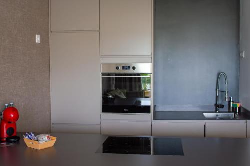 阿德耶Costa Adeje Garden Aparthotel的厨房配有白色橱柜和炉灶烤箱。