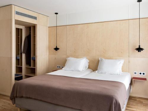巴黎New Hotel Opéra的一间卧室配有一张大床和两个枕头