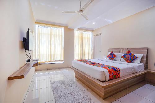 班加罗尔FabHotel BNS Comforts的一间卧室配有一张床和一台平面电视