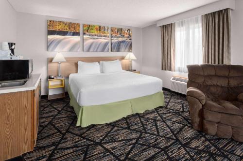 奥加拉拉奥加拉拉戴斯汽车旅馆的配有一张床和一把椅子的酒店客房