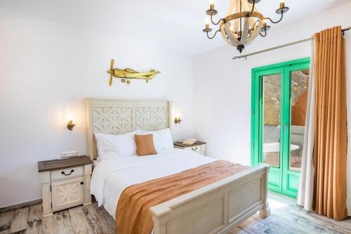 卡尔帕索斯La Scala Luxury Villa Μikis Theodorakis with jacuzzi的一间卧室配有一张床和一个吊灯