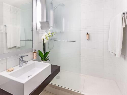 那不勒斯那不勒斯中心安吉尼奥美居酒店的白色的浴室设有水槽和淋浴。