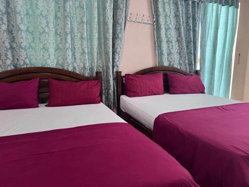 珍南海滩OYO 90981 Chenang Rest House 1的卧室内两张并排的床