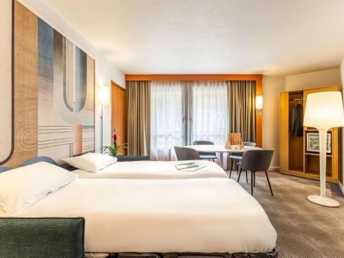 里尔诺沃特里尔中央车站酒店的酒店客房设有两张床和一张桌子。