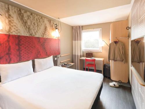 富恩拉夫拉达宜必思马德里丰拉夫拉达酒店的酒店客房,设有白色的床和红色的墙壁