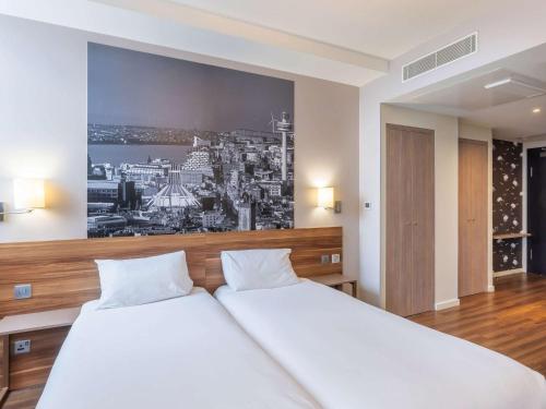 利物浦利物浦市中心阿德吉奥公寓式酒店的卧室配有一张白色床,墙上挂着一幅画