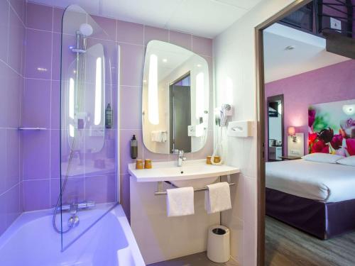 布尔日布尔吉宜必思尚品酒店的一间带水槽和淋浴的浴室以及一张床