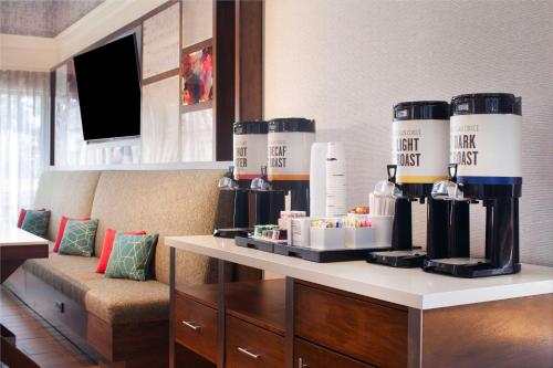 亚特兰大北-I-85亚特兰大机场-汉普顿套房酒店的一间配备有沙发及带酒瓶的桌子的客房