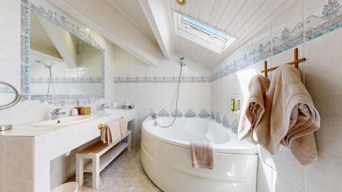 图尔图珀蒂特旅馆的带浴缸、盥洗盆和卫生间的浴室