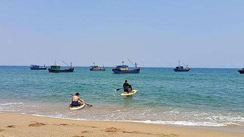 Phú HiệpHomestay Beach View 2的两人在海上的桨板上划船