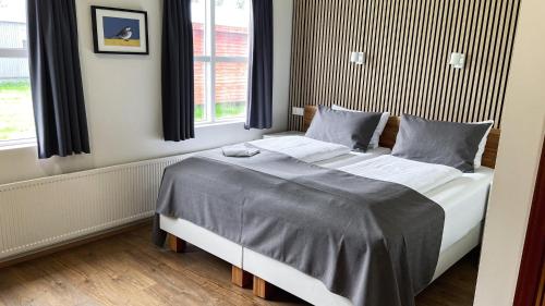 埃基斯蒂尔斯基帕來库尔旅馆的一间卧室配有一张带灰色床单的大床