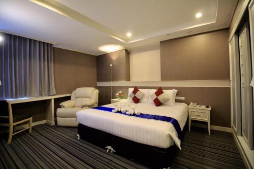 坤敬โรงแรมวีวิช V Wish Hotel的配有一张床和一把椅子的酒店客房