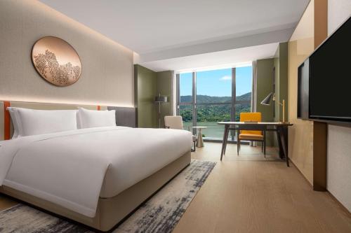 台州台州开投温德姆酒店的酒店客房设有一张大床和一张书桌。