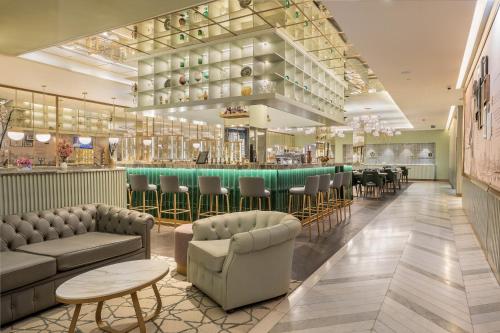里斯本The Emerald House Lisbon - Curio Collection By Hilton的餐厅设有带沙发和椅子的酒吧