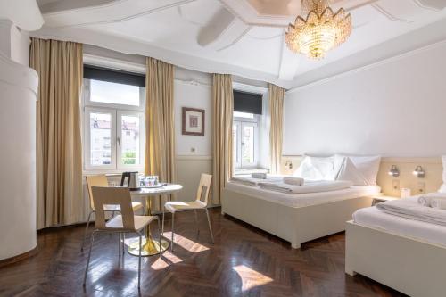 格拉茨Best Western Hotel Strasser的一间卧室配有一张大床和一张桌子及椅子