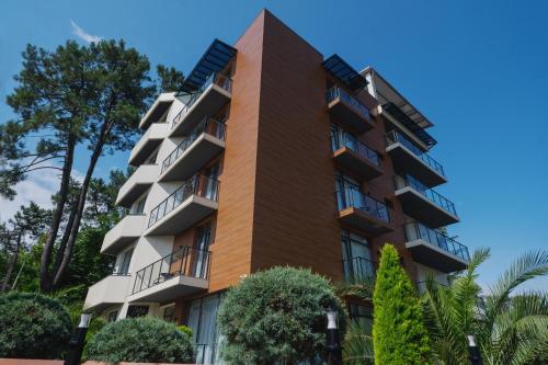 乌雷基Ritsa Resort的公寓大楼设有阳台和树木